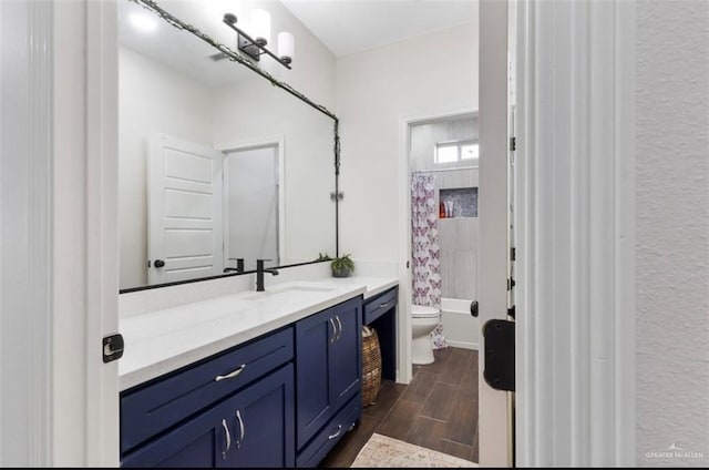 bathroom featuring wood finish floors, toilet, shower / tub combo with curtain, and vanity