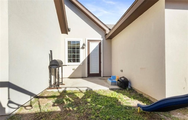 doorway to property with a patio area and stucco siding