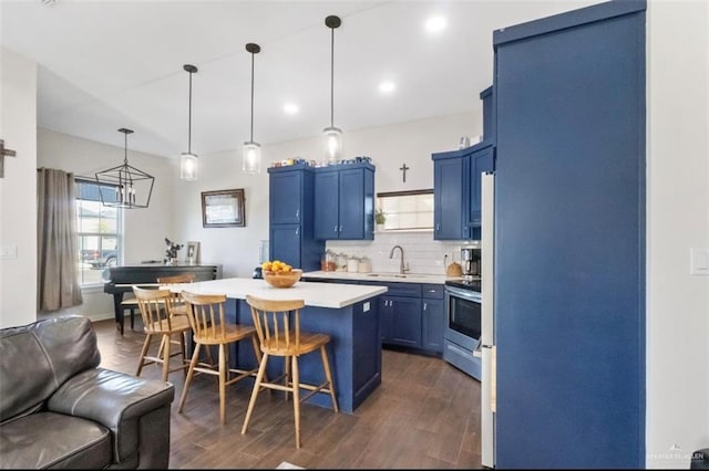 kitchen featuring tasteful backsplash, a kitchen island, light countertops, blue cabinets, and a sink