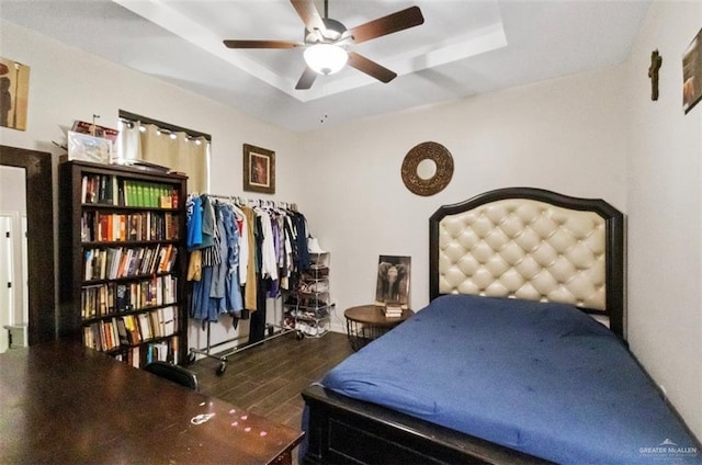 bedroom featuring a raised ceiling and wood finished floors