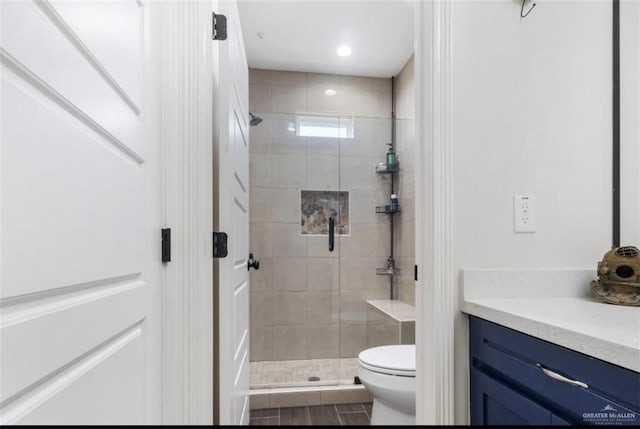 full bathroom featuring a stall shower, toilet, and vanity