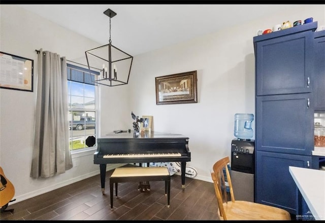 sitting room with a chandelier, baseboards, and wood finish floors