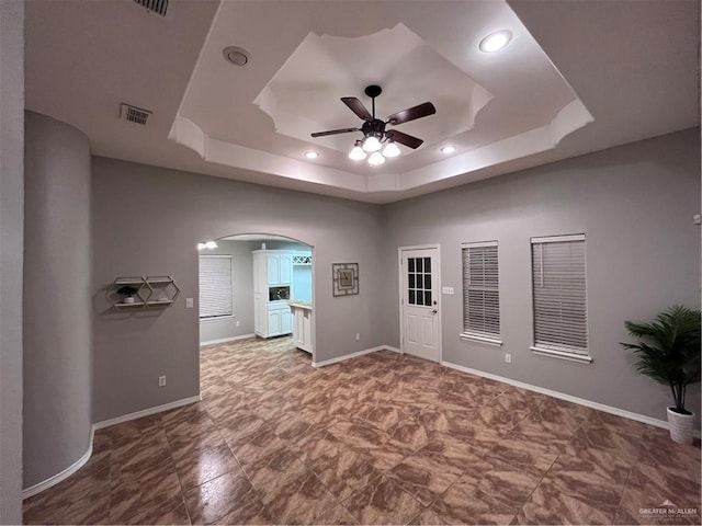 3404 Robin Ave, Pharr, TX 78577 - spare room with a ceiling fan, arched walkways, a tray ceiling, recessed lighting, and baseboards