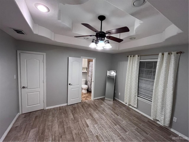 3404 Robin Ave, Pharr, TX 78577 - unfurnished bedroom with a raised ceiling, wood finished floors, baseboards, and ensuite bathroom