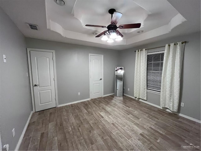 3404 Robin Ave, Pharr, TX 78577 - unfurnished bedroom featuring a raised ceiling, wood finished floors, baseboards, and ceiling fan