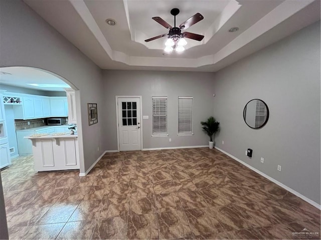 3404 Robin Ave, Pharr, TX 78577 - spare room featuring a ceiling fan, a tray ceiling, arched walkways, and baseboards