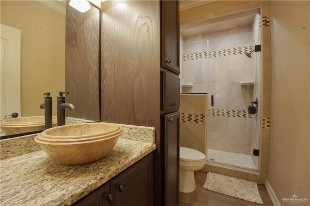 bathroom with vanity, ornamental molding, toilet, and walk in shower