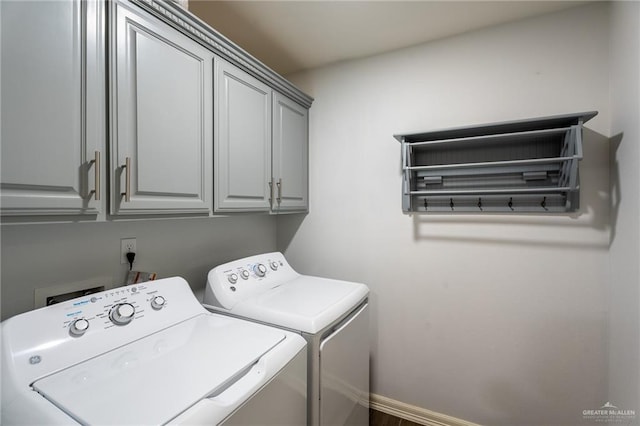 laundry area featuring baseboards, cabinet space, and washing machine and clothes dryer