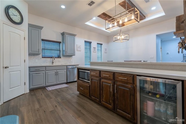 kitchen featuring an inviting chandelier, visible vents, appliances with stainless steel finishes, a raised ceiling, and wine cooler