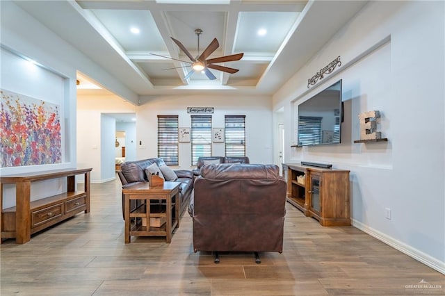 living area featuring wood finished floors, beam ceiling, baseboards, ceiling fan, and coffered ceiling