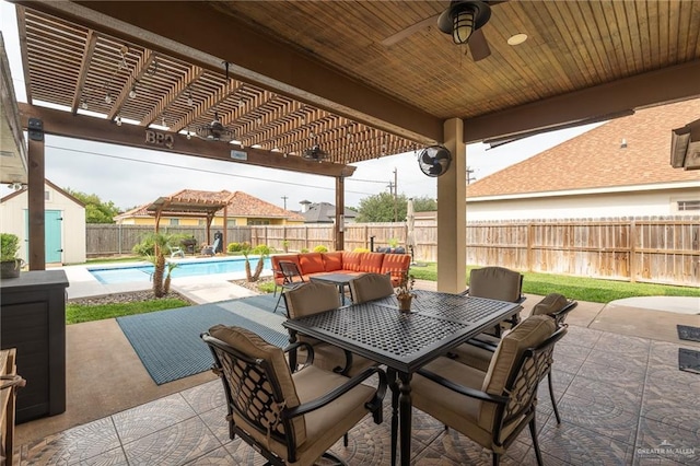 view of patio / terrace featuring a storage unit, a pergola, ceiling fan, a fenced backyard, and a fenced in pool