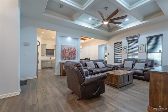 living area with dark wood-style flooring, ceiling fan, beam ceiling, and coffered ceiling