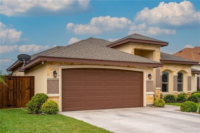 view of front of house with concrete driveway, fence, stone siding, and a garage