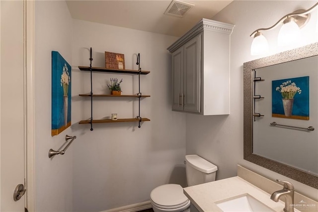 bathroom with vanity, toilet, and visible vents