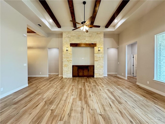 unfurnished living room with ceiling fan, beam ceiling, and light hardwood / wood-style flooring