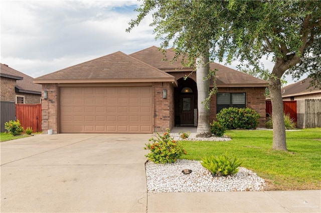 ranch-style house featuring brick siding, an attached garage, a front yard, fence, and driveway