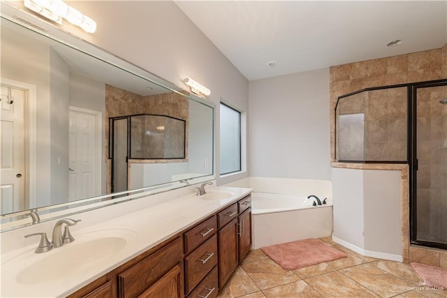 bathroom featuring a bath, a shower stall, double vanity, and a sink