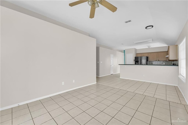 unfurnished living room with a ceiling fan, light tile patterned flooring, visible vents, and baseboards