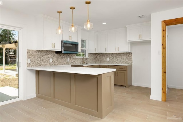 2901 Upas Ave, Mcallen, TX 78501 - kitchen featuring tasteful backsplash, a peninsula, light wood-style flooring, white cabinetry, and light countertops