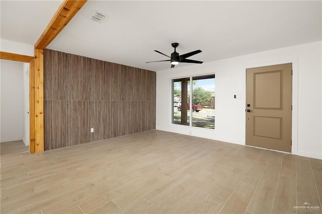 2901 Upas Ave, Mcallen, TX 78501 - unfurnished living room featuring wooden walls, light wood-style floors, visible vents, and ceiling fan