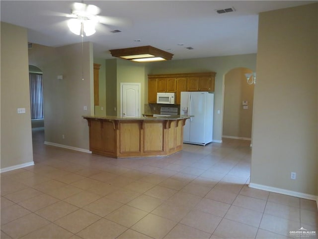 2603 Norma Dr, Mission, TX 78574 - kitchen featuring white appliances, arched walkways, a peninsula, a kitchen breakfast bar, and a ceiling fan