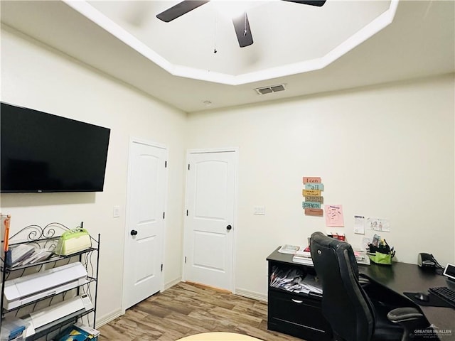 office featuring ceiling fan, visible vents, light wood-style flooring, and baseboards