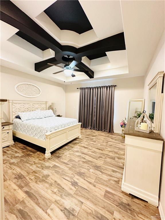 bedroom with light wood finished floors, baseboards, coffered ceiling, and a ceiling fan