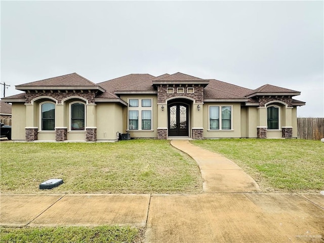 view of front facade with french doors, a front yard, and stucco siding