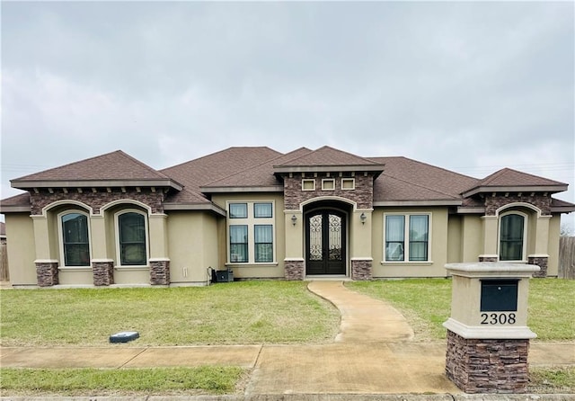 view of front facade with a shingled roof, french doors, a front lawn, and stucco siding