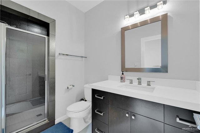 bathroom with a stall shower, vanity, and toilet