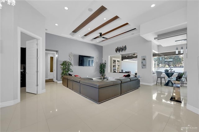 living area with baseboards, beam ceiling, a ceiling fan, and tile patterned floors