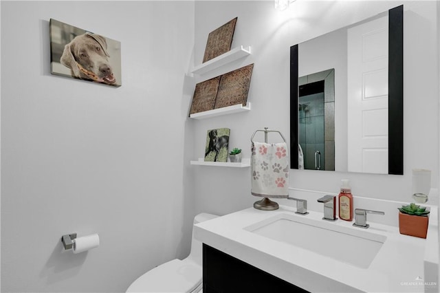 bathroom featuring vanity, toilet, and a shower with door