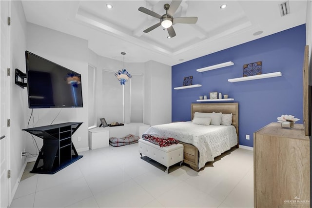 bedroom with a raised ceiling, visible vents, and baseboards