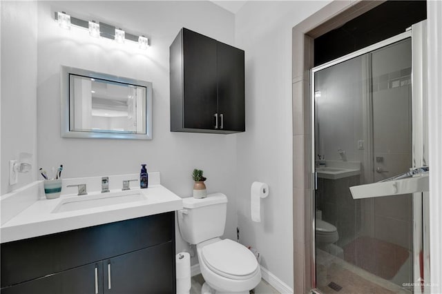 bathroom featuring a stall shower, vanity, toilet, and baseboards