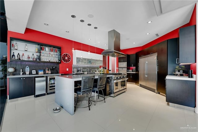 kitchen featuring built in appliances, a breakfast bar area, modern cabinets, island exhaust hood, and pendant lighting