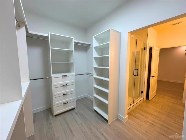 spacious closet with light hardwood / wood-style flooring