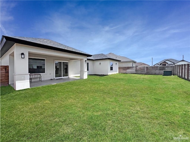 rear view of property with a yard and a patio