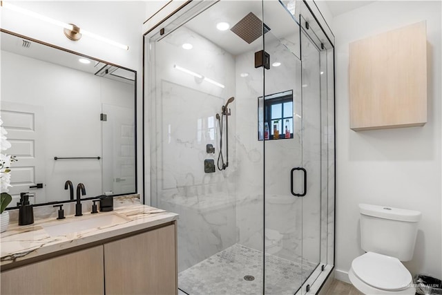 bathroom with vanity, an enclosed shower, and toilet