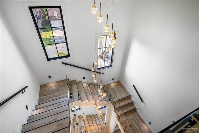 stairway with a healthy amount of sunlight and hardwood / wood-style flooring