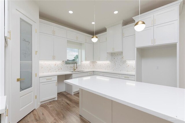 5706 N 44th Ln, Mcallen, TX 78504 - kitchen featuring light wood finished floors, decorative backsplash, white cabinets, and recessed lighting