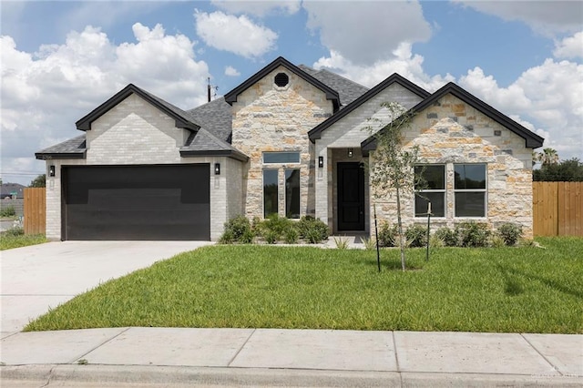5706 N 44th Ln, Mcallen, TX 78504 - view of front facade featuring an attached garage, concrete driveway, stone siding, and a shingled roof