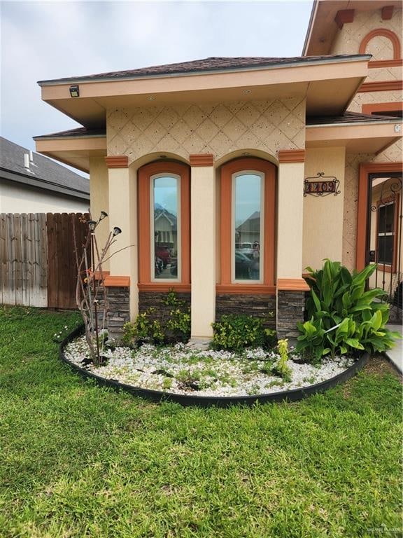 view of exterior entry with a yard