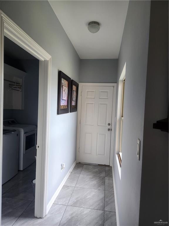 corridor featuring light tile patterned floors and separate washer and dryer