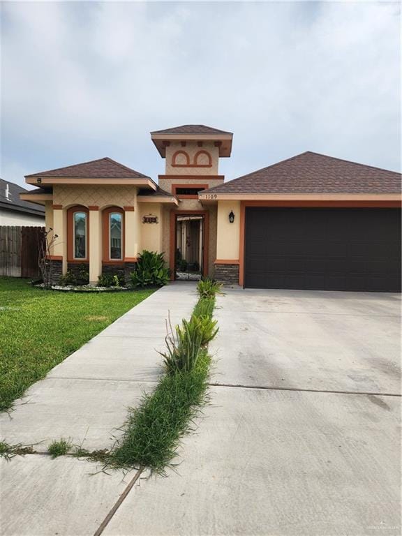 prairie-style house featuring a front lawn and a garage