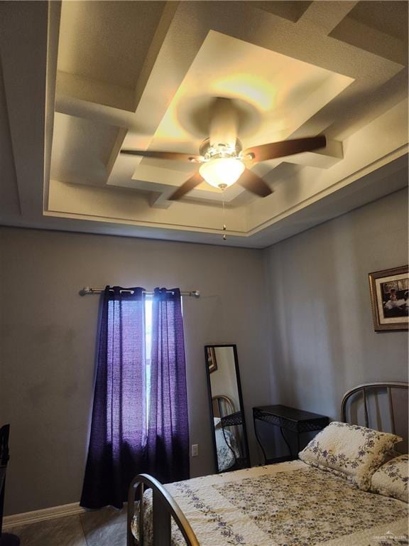 bedroom with a raised ceiling and ceiling fan