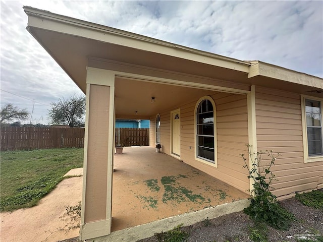 view of home's exterior with a patio area and fence