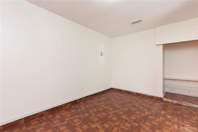 unfurnished room featuring dark parquet flooring