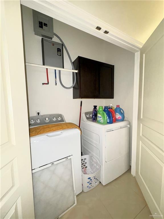 clothes washing area with washer and dryer and cabinets