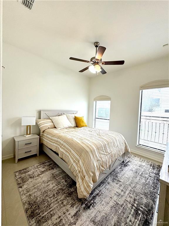 bedroom featuring multiple windows and ceiling fan