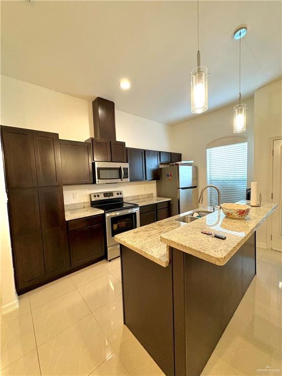 kitchen with an island with sink, appliances with stainless steel finishes, sink, and hanging light fixtures